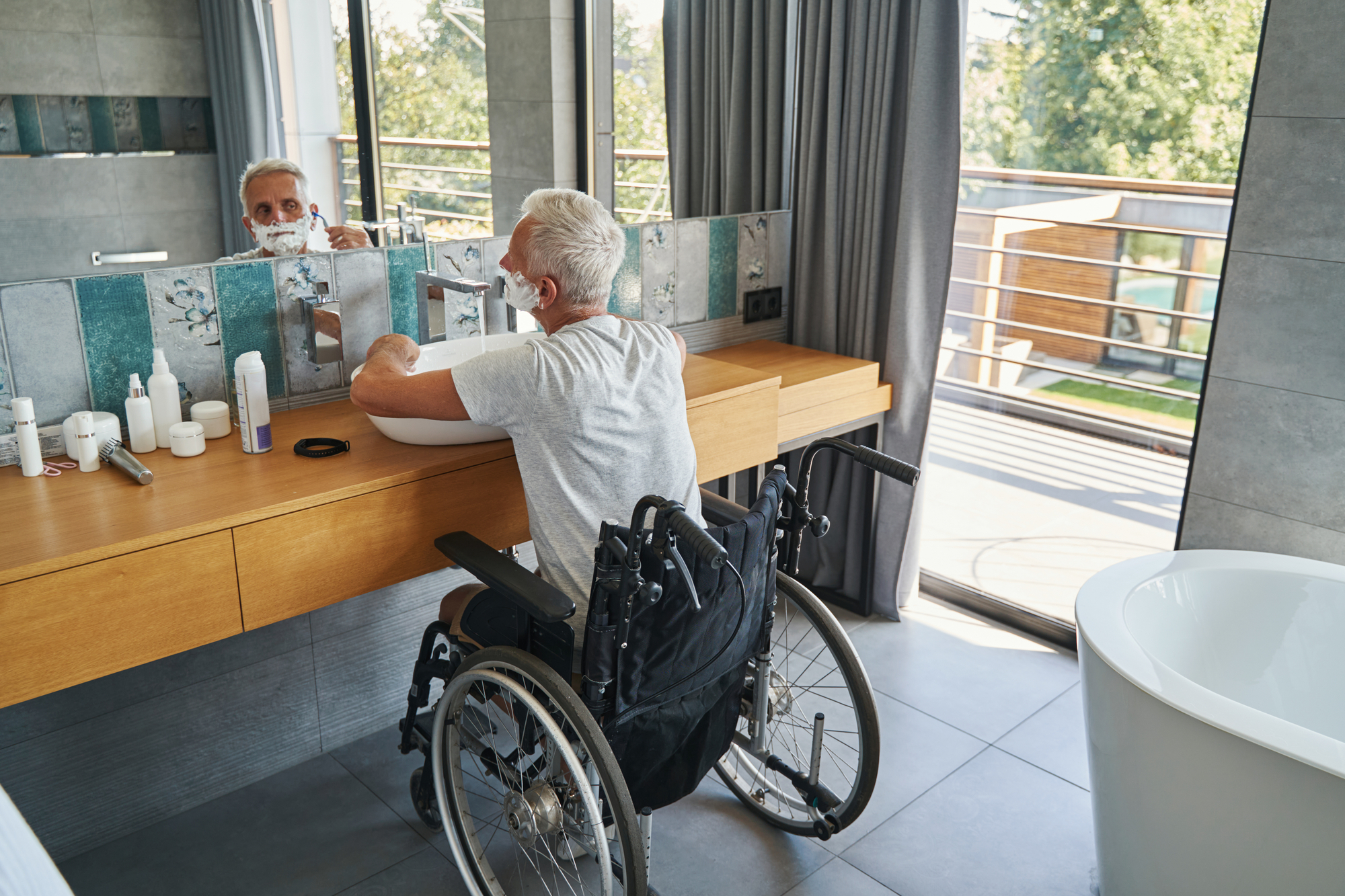 man-shaving-in-wheelchair-in-mobility-bathroom